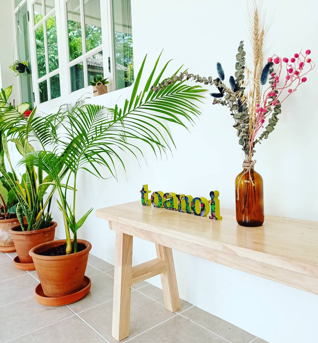 The Toanoi House entrance with plants and a wooden bench