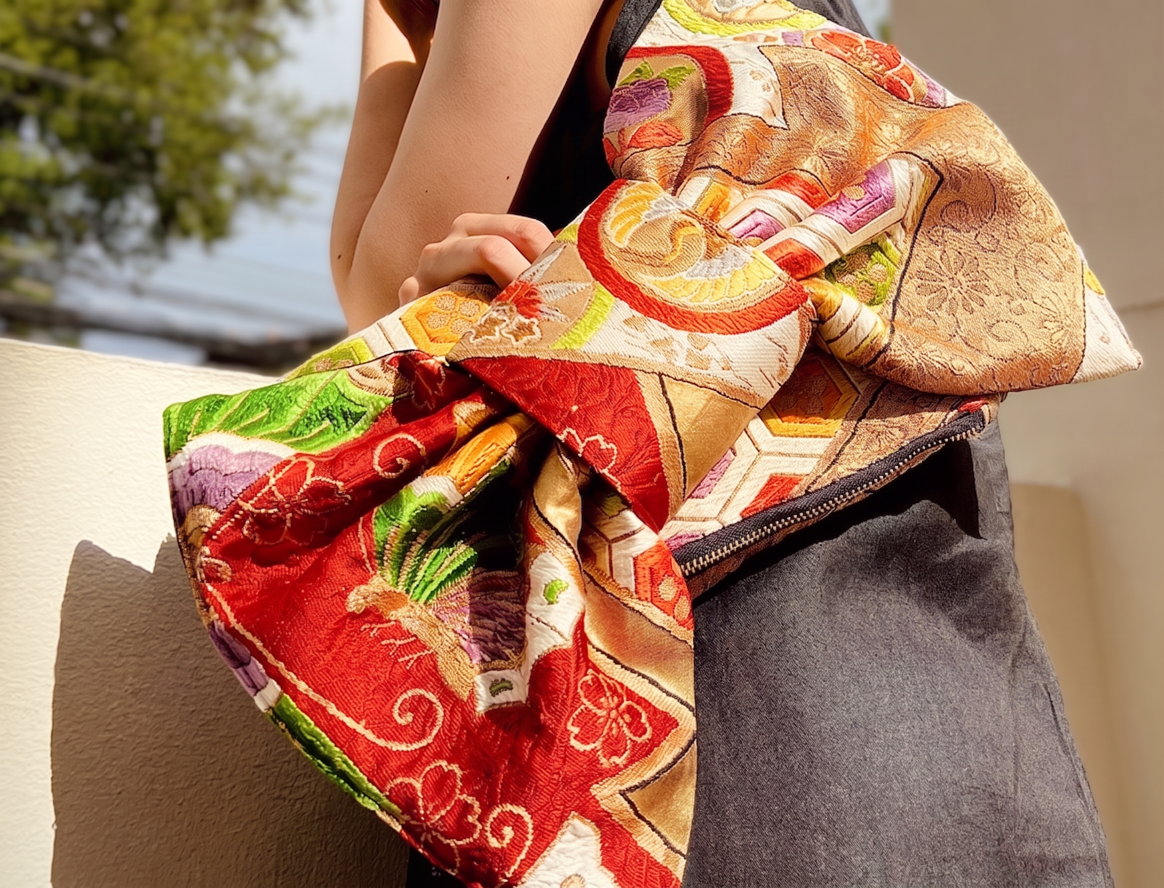 A kimono ribbon clutch being tied by hand